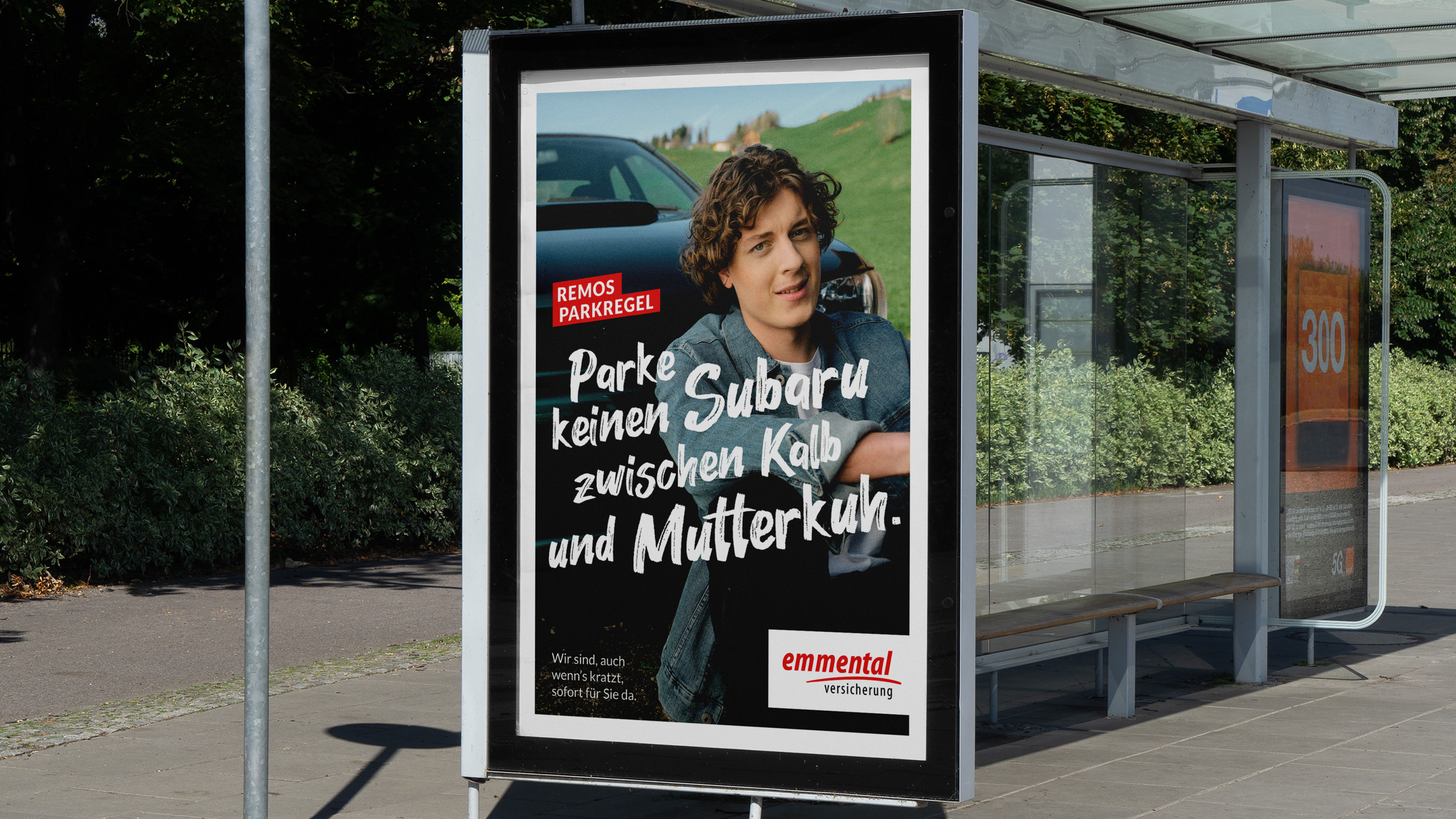 Werbesujet mit dem Slogan "Parke keinen Subaru zwischen Kalb und Mutterkuh.", dass einen jungen Mann mit Jeansjacke zeigt, wie er vor dem Kühlergrill seines Subarus auf dem Boden sitzt.