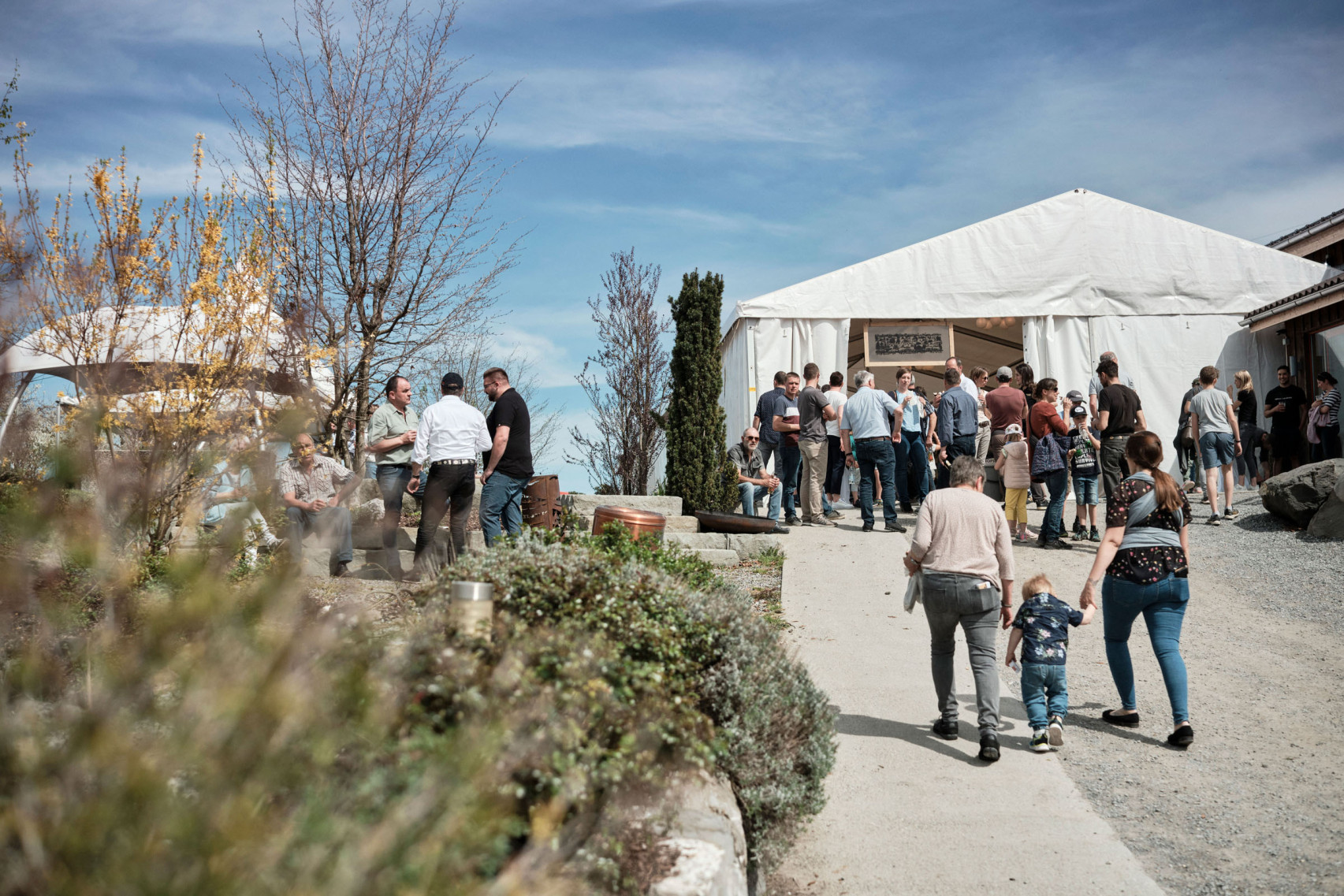 Menschen versammeln sich vor und in einem Festzelt während der Gewinnausschüttung der emmental versicherung.