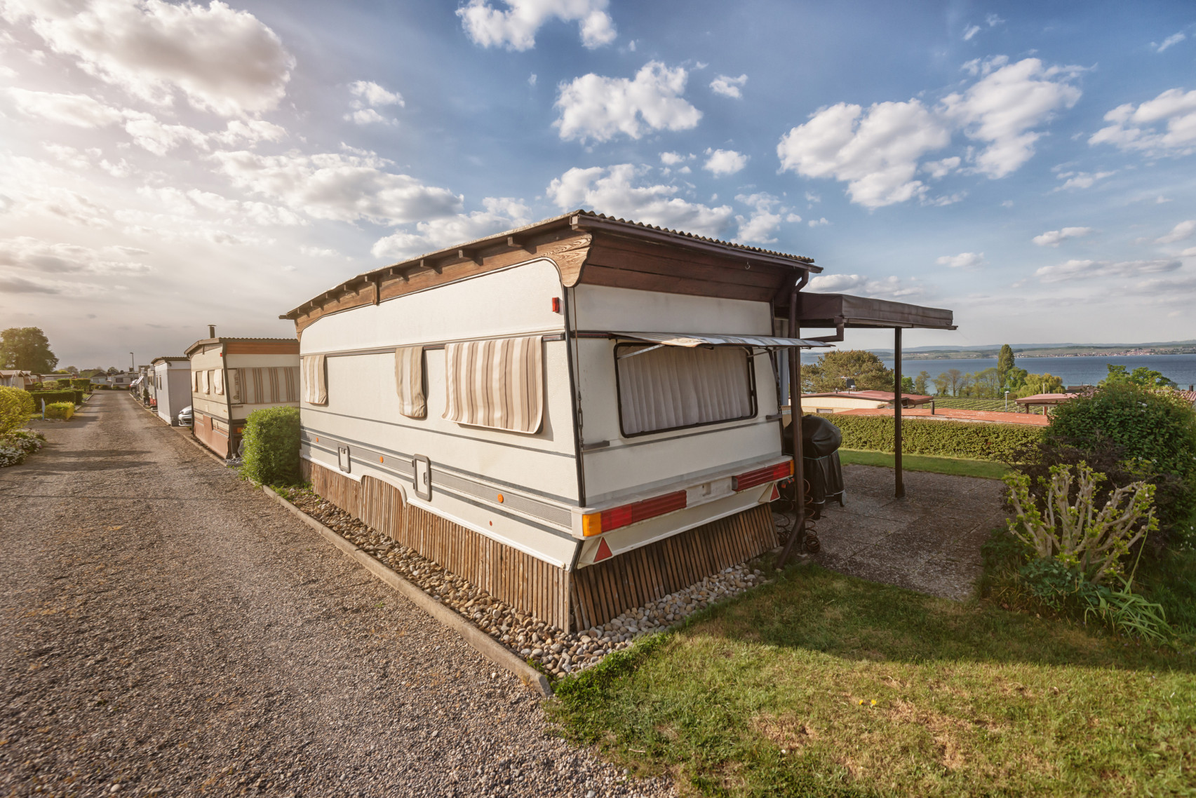 Ein fest stationierter Wohnwagen auf einem Campingplatz am Bodensee an einem sonnigen Tag.